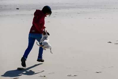 Full length of woman playing with dog outdoors