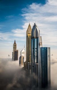 View of skyscrapers against cloudy sky