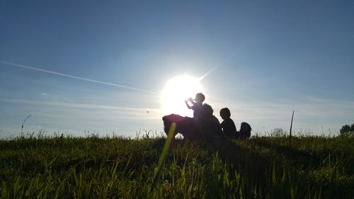 Scenic view of grassy field against sky during sunset