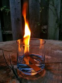 Close-up of fire in drink on wooden table