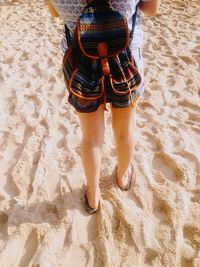 Low section of woman standing on shore