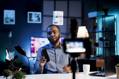 Portrait of young man using mobile phone in office