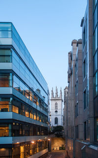 Buildings in city against clear blue sky