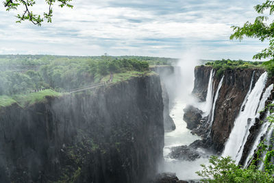 Scenic view of waterfall against sky