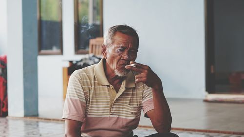 Portrait of man looking away while standing outdoors