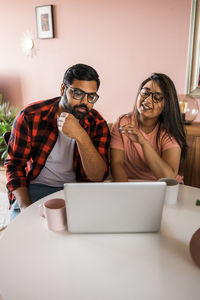 Young woman using laptop at table