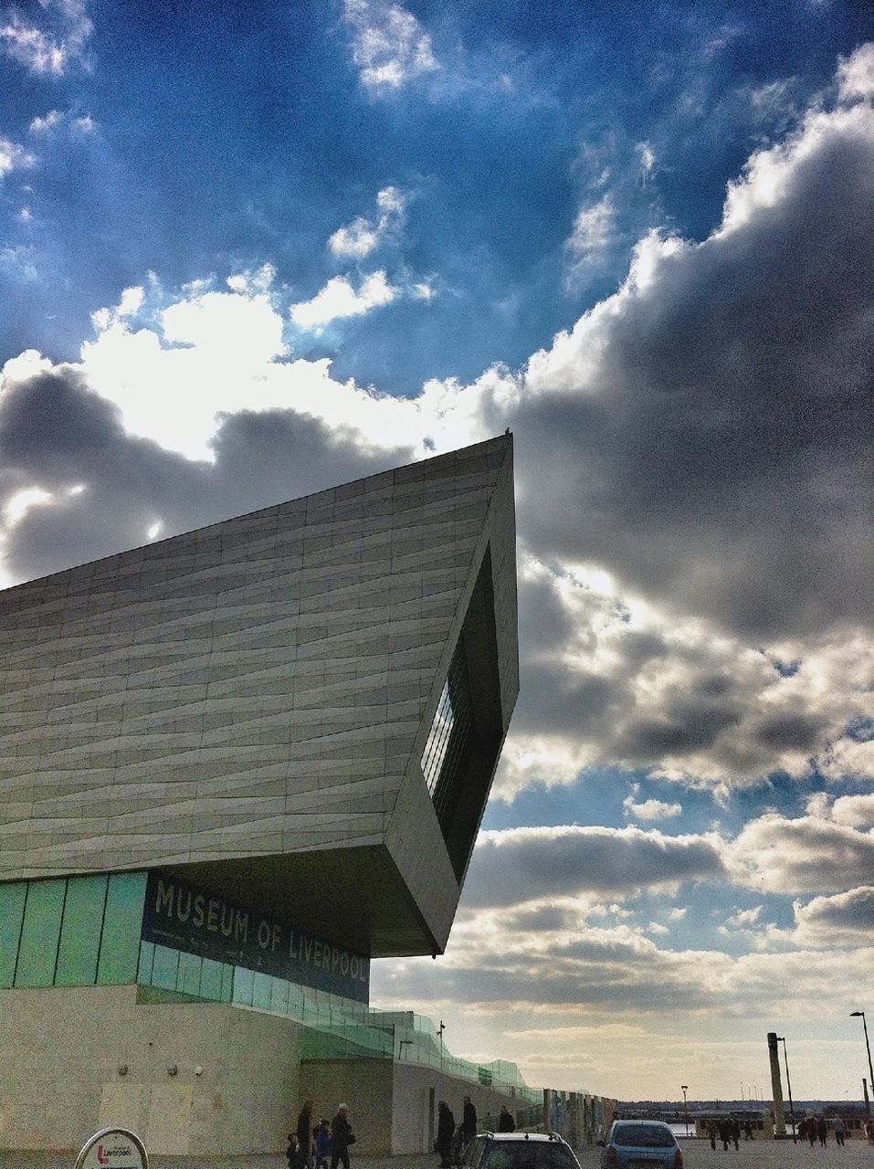 sky, building exterior, architecture, built structure, cloud - sky, cloudy, cloud, low angle view, city, building, day, outdoors, modern, transportation, sunlight, city life, street, no people, residential building, incidental people