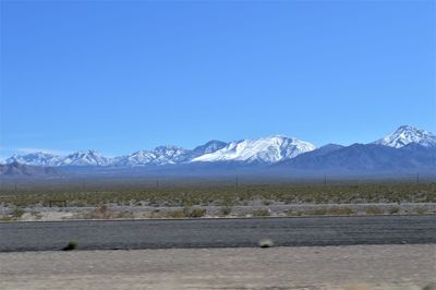 Scenic view of snowcapped mountains against clear blue sky