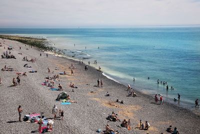 Panoramic view of people on beach against sky