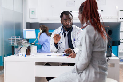 Doctor talking with pregnant woman in clinic