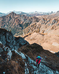 Person on rocks against mountain range