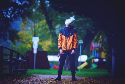 Man with umbrella standing in park