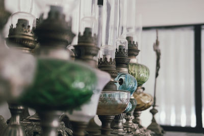 Close-up of antique oil lamps on table