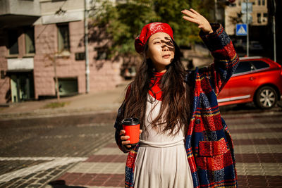 Asian girl with coffee walking on street in autumn