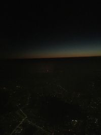 Aerial view of illuminated cityscape against sky at night