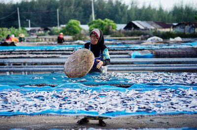 Rear view of woman working in water