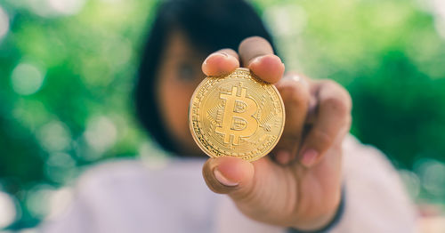 Close-up of woman holding bitcoin
