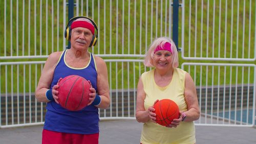 Portrait of smiling young woman playing with ball in gym