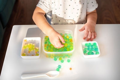 High angle view of boy holding food on table