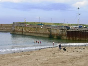 People on beach against sky