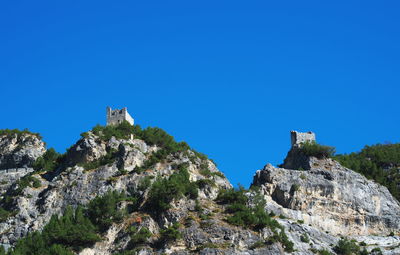 Low angle view of rock formation against clear blue sky