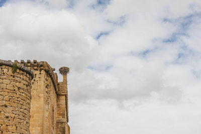 Low angle view of old building against cloudy sky