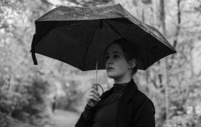 Woman holding umbrella standing outdoors