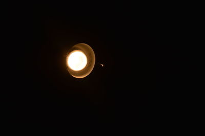 Low angle view of illuminated moon against sky at night