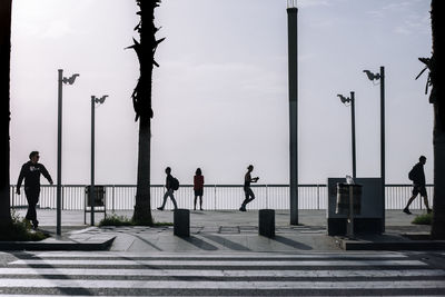 People walking on street against sky