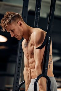 Shirtless man exercising in gym