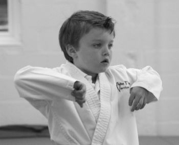 Boy in sport clothing standing at martial arts classroom