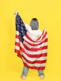 Rear view of woman holding american flag