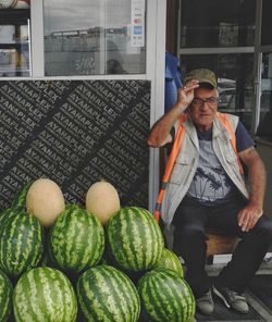 Portrait of man holding watermelons