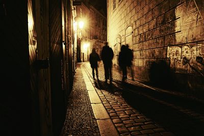 People walking on sidewalk at night