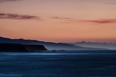 Scenic view of sea against sky during sunset in foggy weather