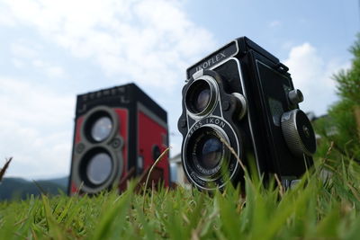 Close-up of camera on field against sky