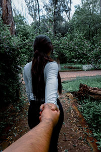 Rear view of woman standing in forest