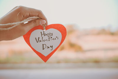 Close-up of hand holding heart shape with text