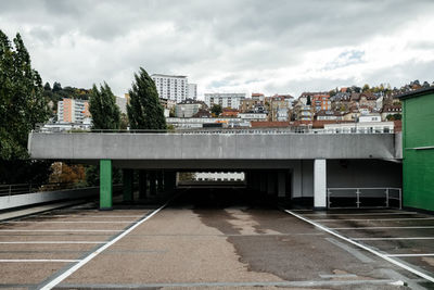 Road by buildings against sky in city