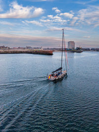 Sailboat sailing on sea against sky