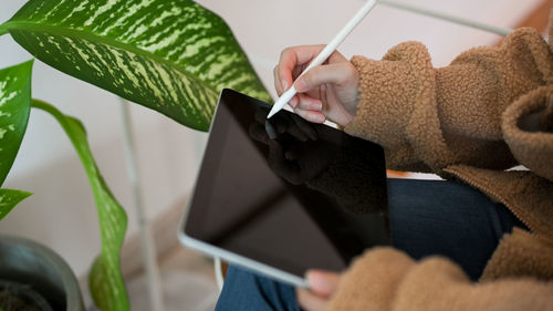 Cropped hand of woman using mobile phone