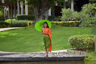 Full length of woman standing by plants