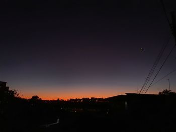 Silhouette buildings against sky during sunset