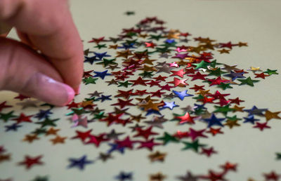 Cropped hand of woman with colorful stars on table