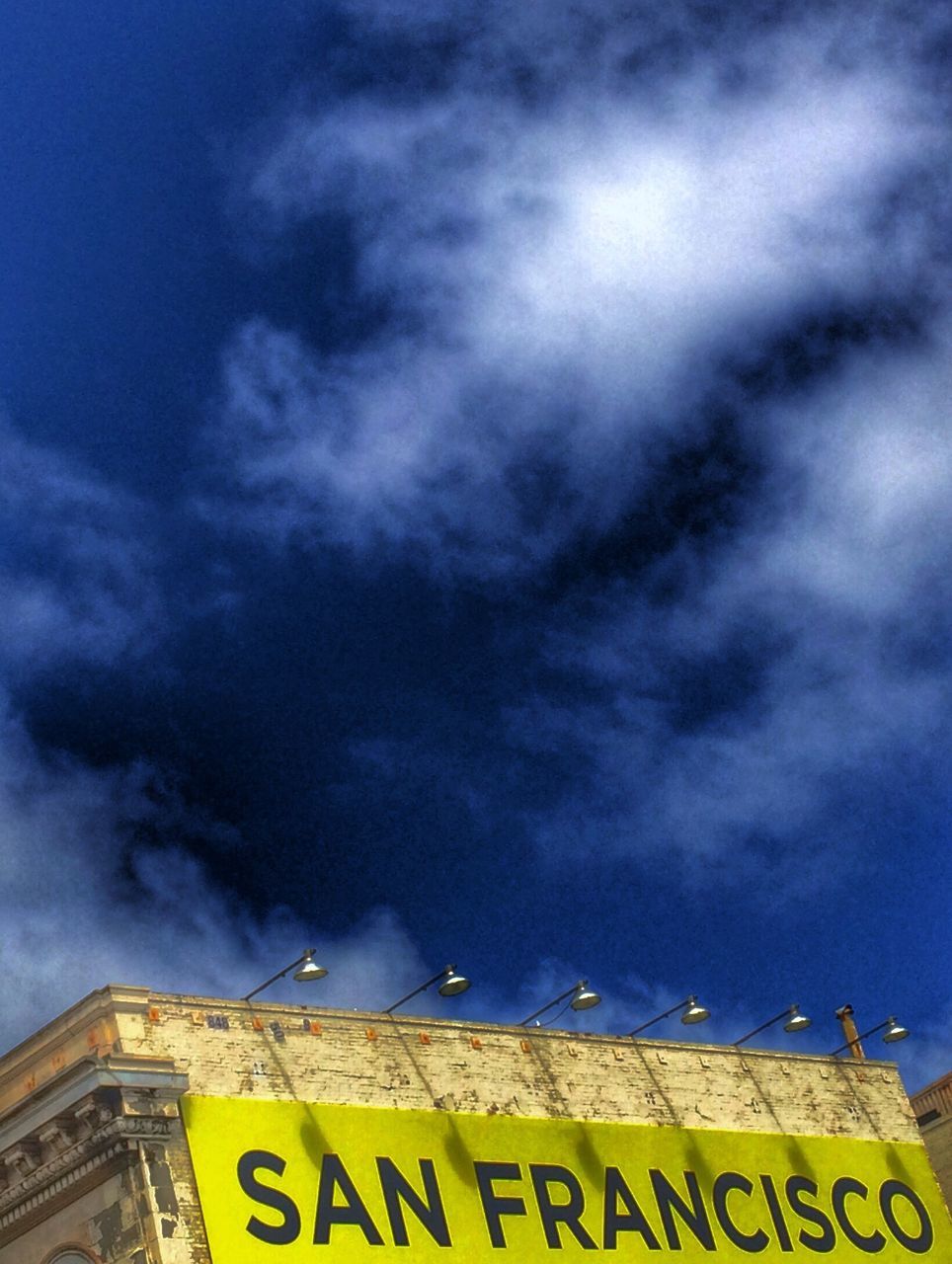 low angle view, text, sky, cloud - sky, western script, communication, cloudy, cloud, information sign, information, capital letter, guidance, weather, sign, blue, outdoors, no people, overcast, nature, directional sign