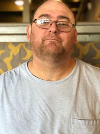 Portrait of man wearing eyeglasses sitting at home