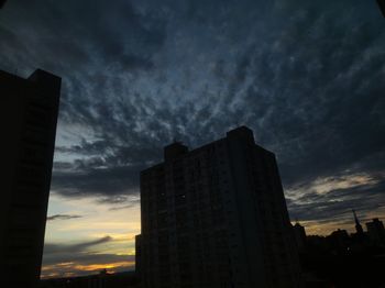 Low angle view of silhouette buildings against sky at sunset