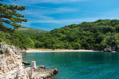 Larger pebble bay with jetties on the croatian coast on a summer day.