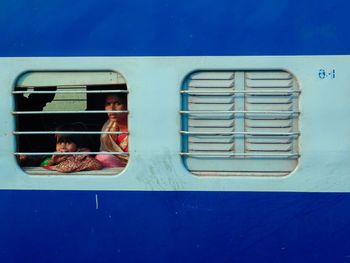 Portrait of mother and daughter seen through train window