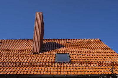 Low angle view of building roof against clear sky